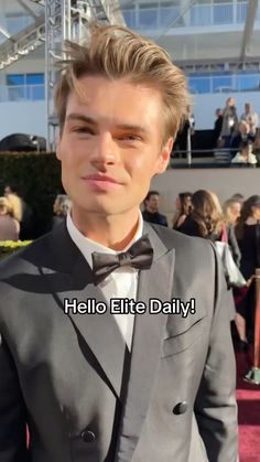 a man in a tuxedo and bow tie on the red carpet at an event