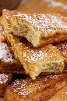 several pieces of french toast stacked on top of each other with powdered sugar over them