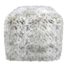 a white fur covered ottoman sitting on top of a table