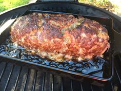 a large piece of meat is cooking on the grill