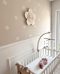 a white crib with a baby's name on the wall next to it