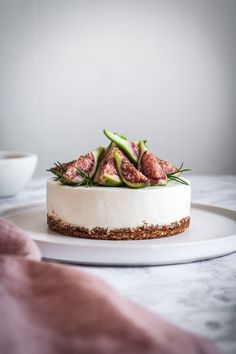 a white plate topped with a cheesecake covered in figurines and strawberries