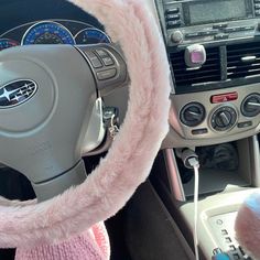 the interior of a car with a steering wheel cover and fuzzy pink fur on it