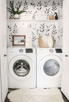 a washer and dryer in a small room with wallpaper on the walls