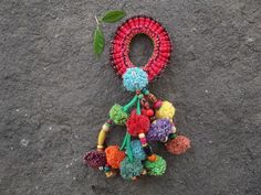 a bunch of pom poms hanging from a string on top of a rock