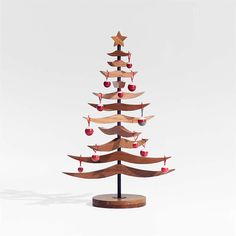 a small wooden christmas tree with red berries and stars on it's top is shown