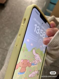 a person holding up an iphone with cartoon images on the screen and in front of them