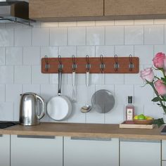 a kitchen counter with flowers and pots on top of it, next to a pot rack