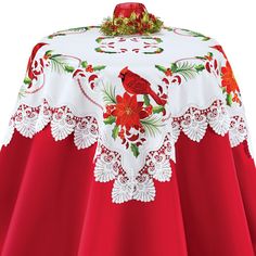 a red and white table cloth with a cardinal on it's center piece, decorated with poinsettis