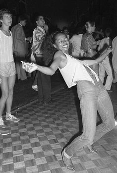 black and white photograph of people dancing on checkered floor