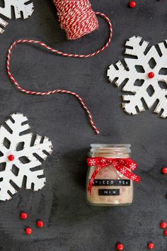 a jar filled with sand next to some red and white snowflakes