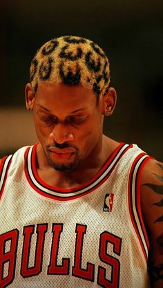 a man in a chicago bulls jersey looking down at his cell phone while wearing a leopard print headband