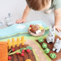 a toddler playing with toys on the floor in front of him and other stuffed animals