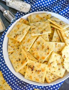 a white bowl filled with crackers on top of a blue and white table cloth