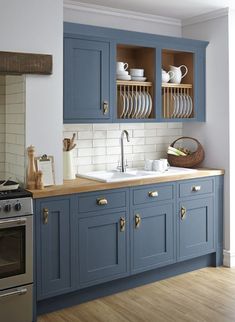 a kitchen with gray cabinets and wooden floors