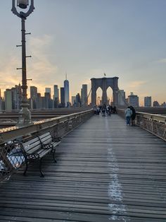 people are walking across a bridge with benches