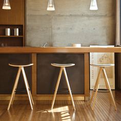 two wooden stools sitting in front of a bar