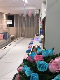 blue and pink roses are in the center of a room with white sheets on the floor