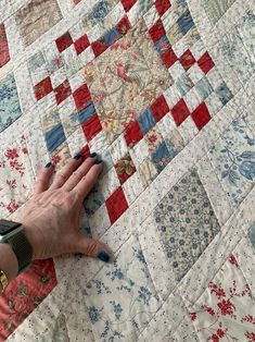 a person's hand on top of a quilt