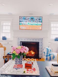 a living room filled with furniture and a flat screen tv mounted above a fire place