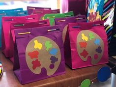 there are many bags that have been painted with different colors and shapes on them,