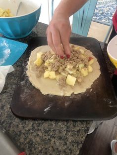 a person is kneading food on top of a doughnut that has been rolled out