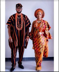 a man and woman dressed in african clothing