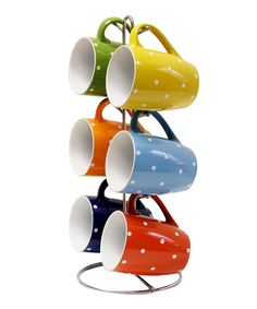 multicolored polka dot coffee mugs are stacked on top of each other