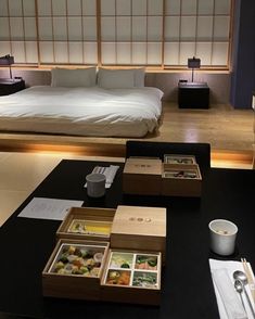 a bed room with a neatly made bed and trays of food