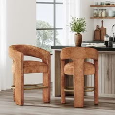 two brown chairs sitting in front of a counter top next to a wooden cabinet and window