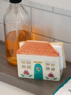 a soap dispenser sitting next to a house shaped soap dish on a counter