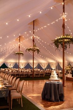 a large tent with tables and chairs set up for a wedding or other function in the evening