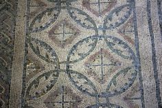 a close up of a very old looking floor with many designs on the tiles and around it