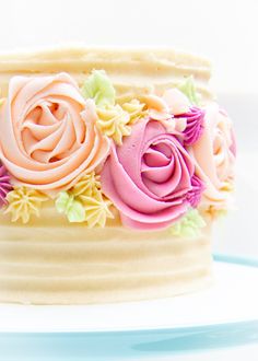 a close up of a frosted cake with flowers on it