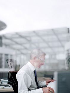 an older man sitting in front of a laptop computer