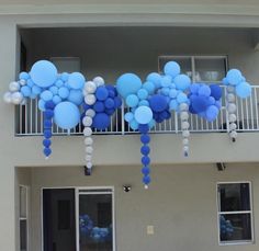 blue and white balloons are hanging from the balconies