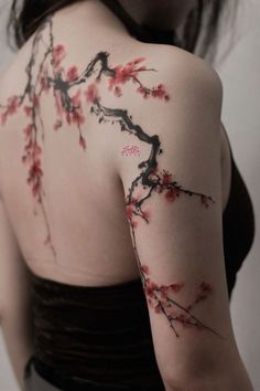 the back of a woman's shoulder with flowers painted on her arm and chest