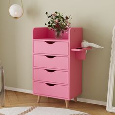 a pink chest of drawers with flowers on top