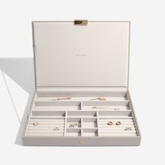 an open white box with jewelry in it