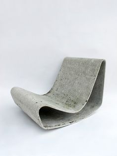 a concrete chair sitting on top of a white floor