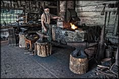 a man standing next to a fire in a room filled with wood and other items