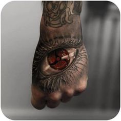 a man's hand with an eye tattoo on it