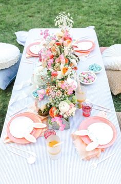 a long table is set with plates and flowers