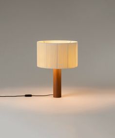 a lamp that is on top of a white surface with a black cord attached to it