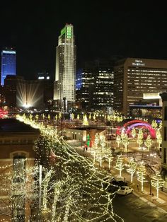 christmas lights are lit up in the city at night