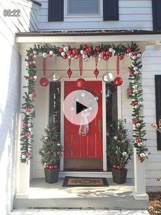 a red front door decorated with christmas decorations