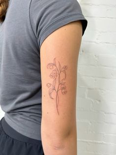 a woman with a flower tattoo on her left arm and right arm behind her back