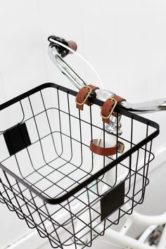 a bicycle basket with two pairs of scissors in the handlebars and clippings