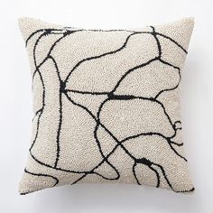 a black and white pillow sitting on top of a white wall