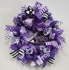 a purple and white wreath with polka dots, ribbons and black and white stripes on it